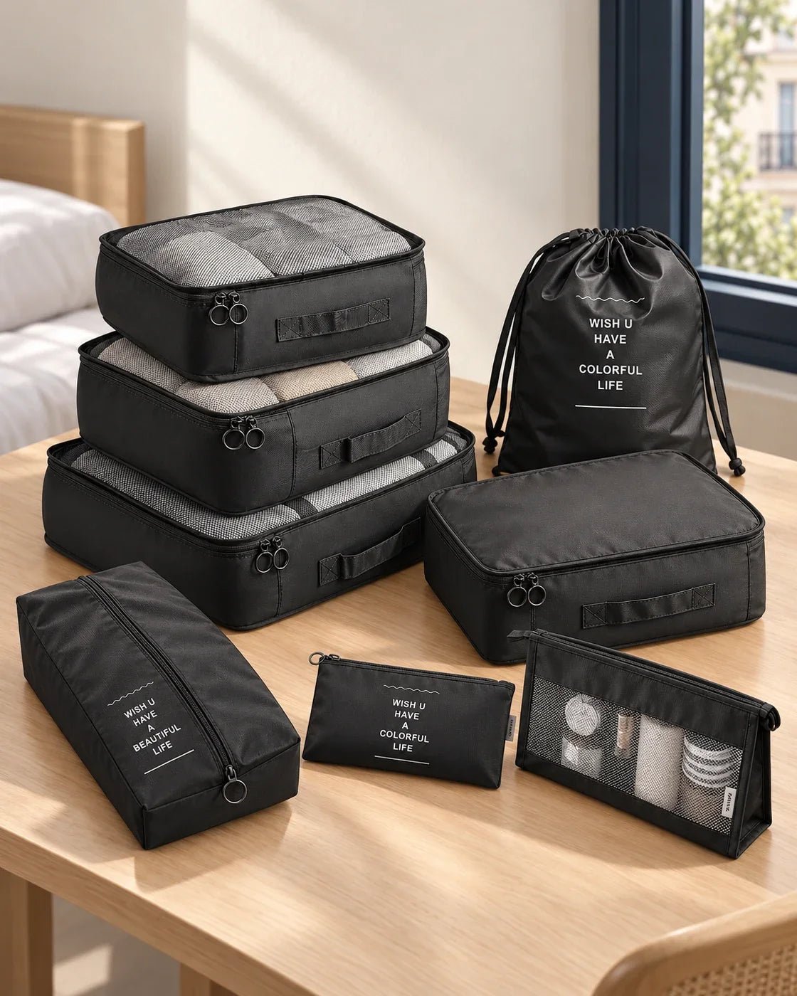 Achtteiliges schwarzes PackSmart Organizer-Set von CARRYON X auf einem hellen Packtisch.