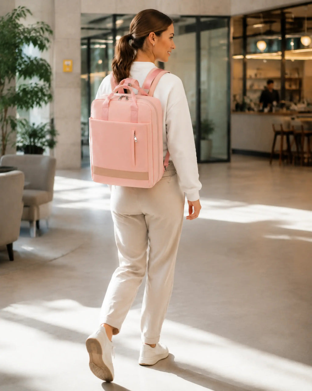 Person mit rosafarbenem CityChic Rucksack in Bewegung in einem modernen Coworking-Bereich.