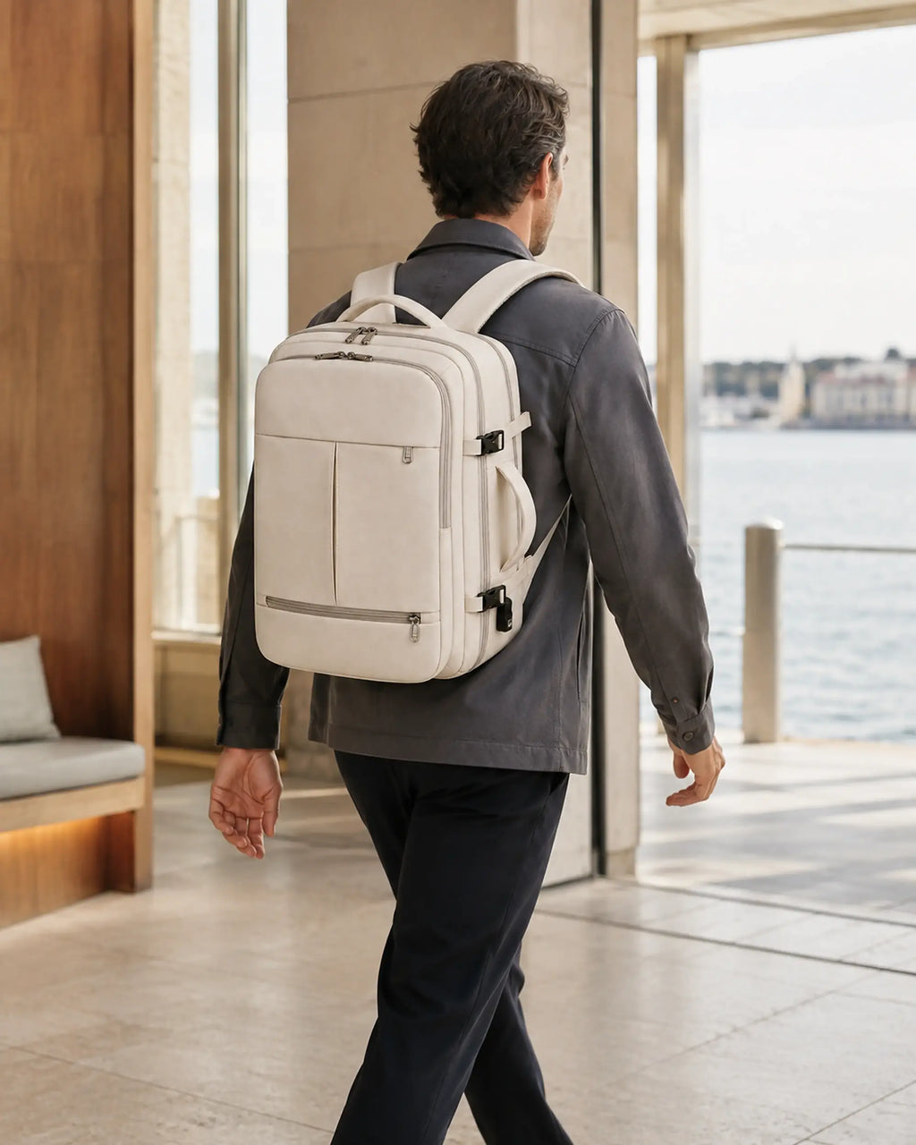 Mann mit beigem MetroSlim Reise-Rucksack auf dem Weg zum Boarding im Fährterminal.