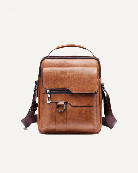 MetroSling Crossbody-Tasche in Braun als Freisteller auf warmweißem Hintergrund.