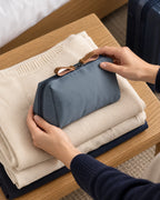 CARRYON X PocketGo Kosmetiktasche in Grau, beim Ablegen auf gefalteter Kleidung.