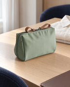 CARRYON X PocketGo Kosmetiktasche in Grün, in einer hellen Hotelumgebung.
