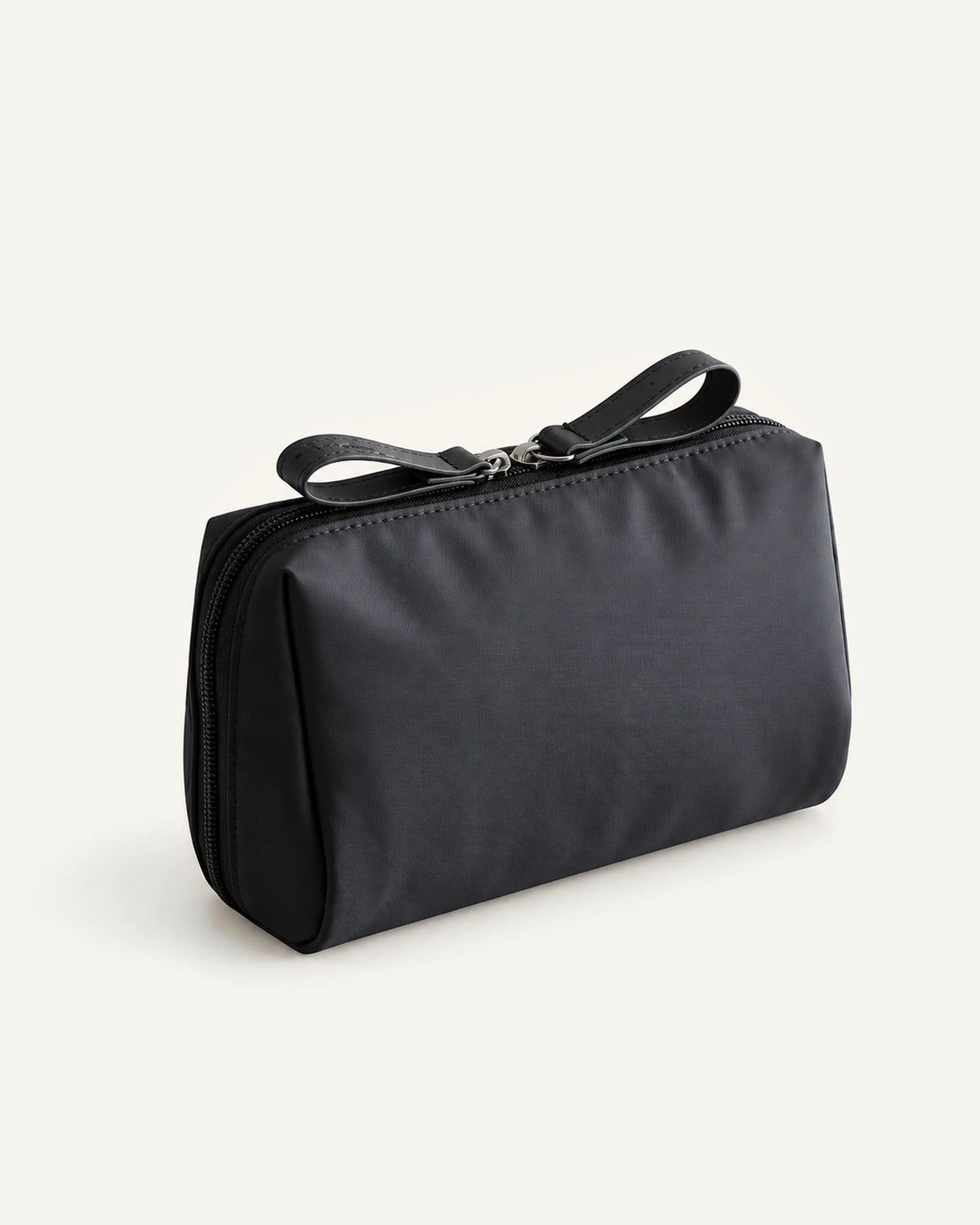 CARRYON X PocketGo Kosmetiktasche in Schwarz, geschlossen vor hellem beigem Hintergrund.