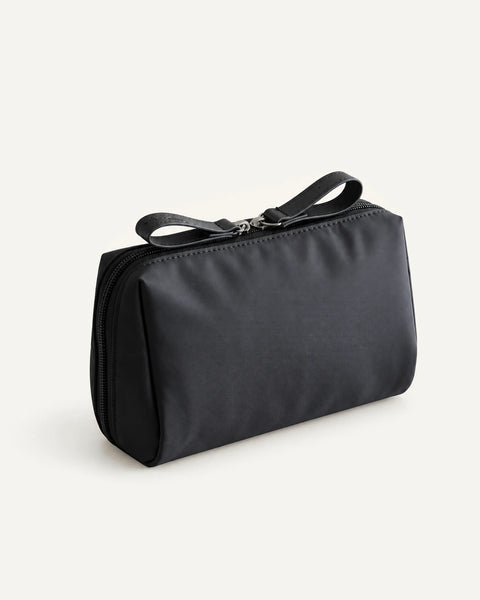 CARRYON X PocketGo Kosmetiktasche in Schwarz, geschlossen vor hellem beigem Hintergrund.
