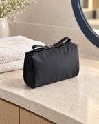 CARRYON X PocketGo Kosmetiktasche in Schwarz, in einer hellen Hotelumgebung.