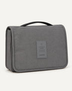 CARRYON X SortCase Kulturbeutel in Grau, geschlossen vor hellem beigem Hintergrund.
