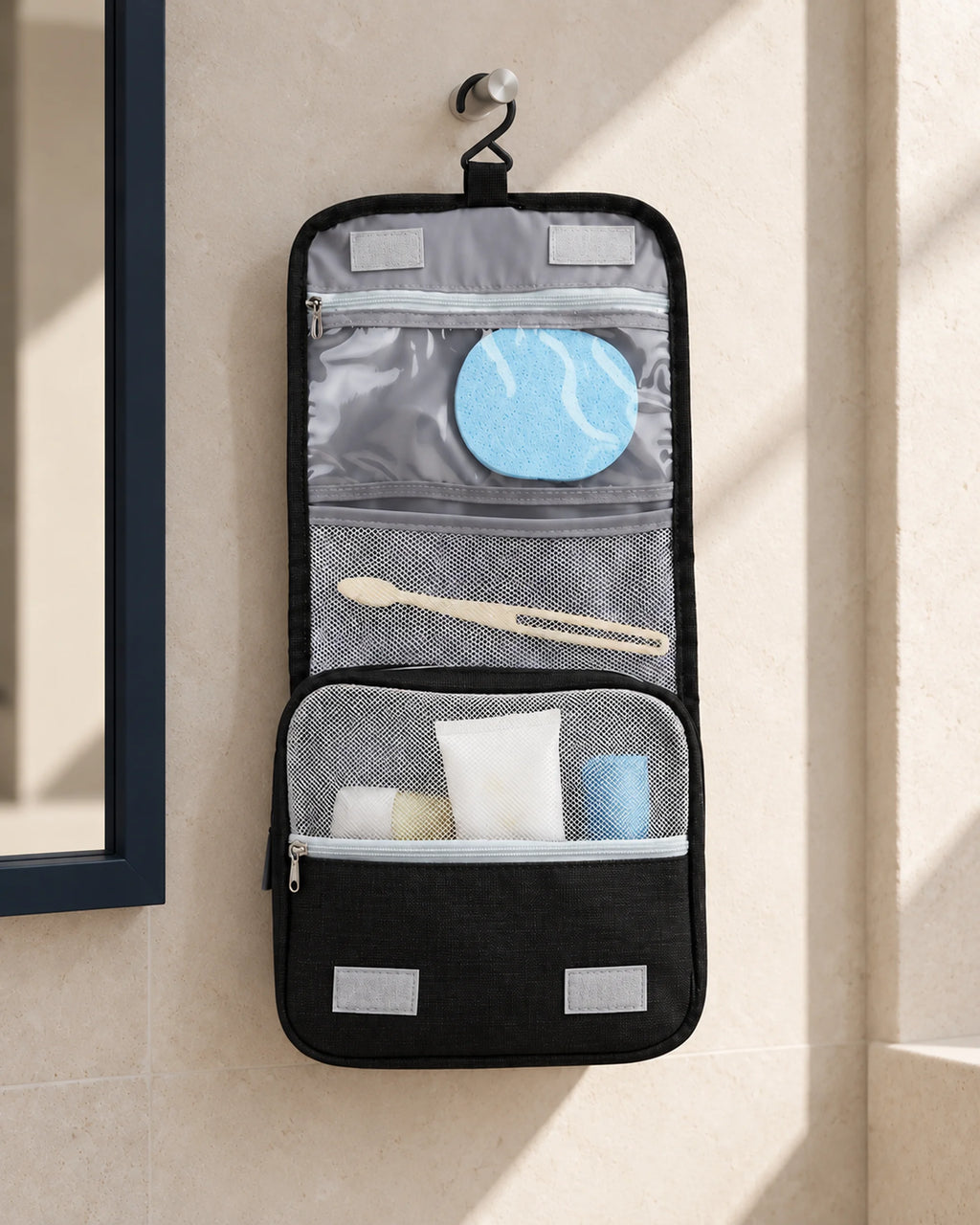 CARRYON X SortCase Kulturbeutel in Schwarz, aufgehängt mit sichtbaren Innenfächern im Hotelbad.