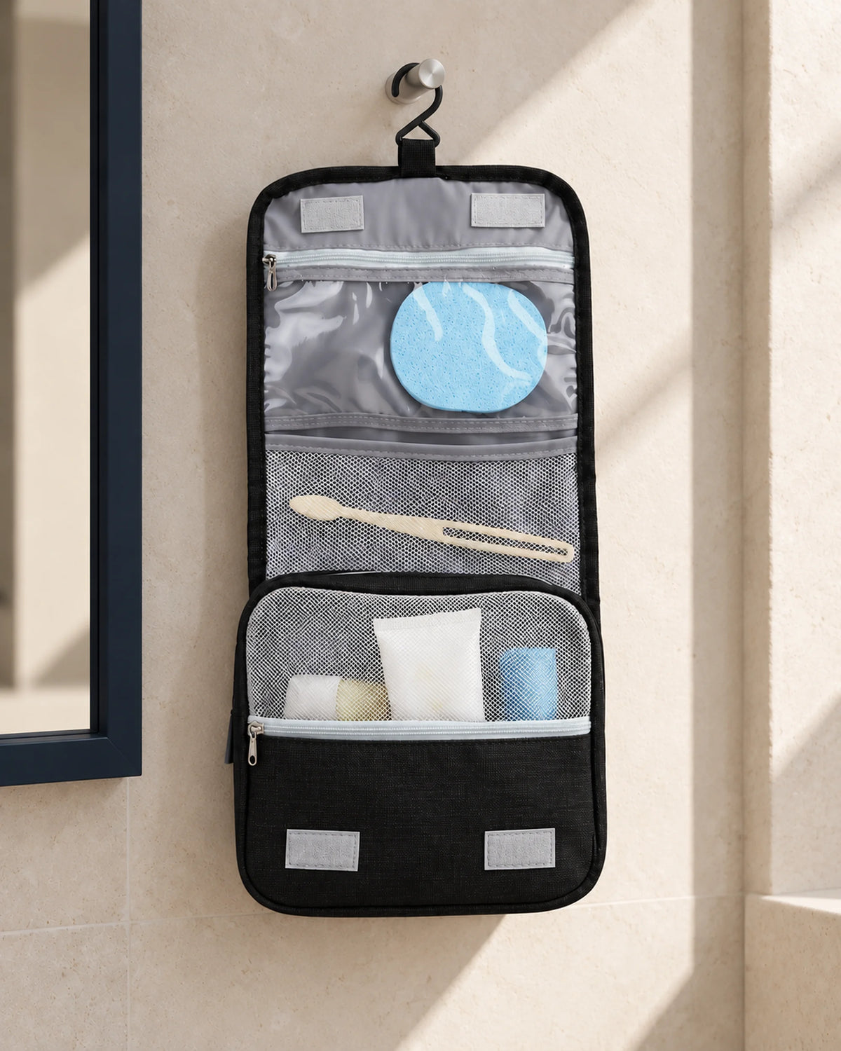 CARRYON X SortCase Kulturbeutel in Schwarz, aufgehängt mit sichtbaren Innenfächern im Hotelbad.
